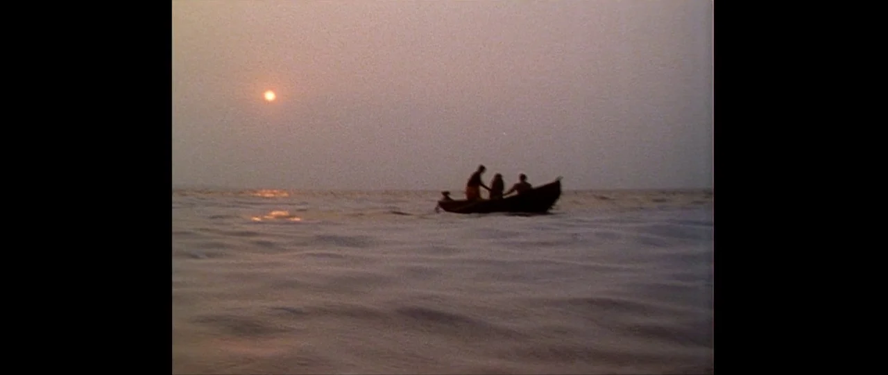 Silence (2012) movie still: wide — A small motorboat drifts on a calm, hazy ocean during the late afternoon. Three people sit inside the vessel…