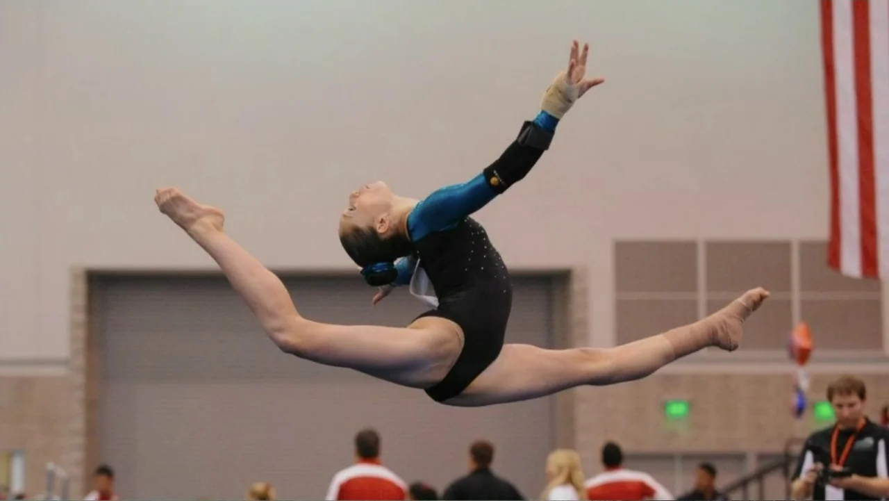 At the Heart of Gold: Inside the USA Gymnastics Scandal (2019) movie still: medium — A gymnasium interior with a large roll-up door and a hanging…