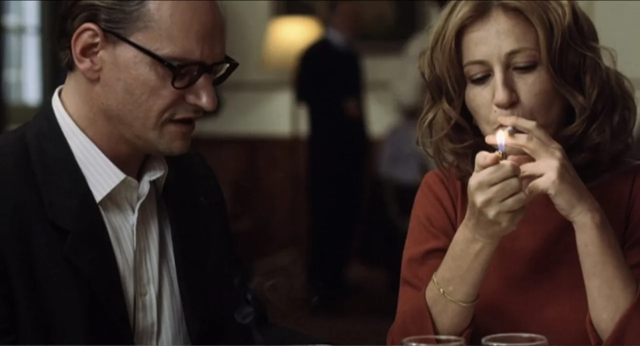The Holy Girl (2004) movie still: medium — A dimly lit indoor dining area with warm, muted tones and soft background blur. A woman sits across from…