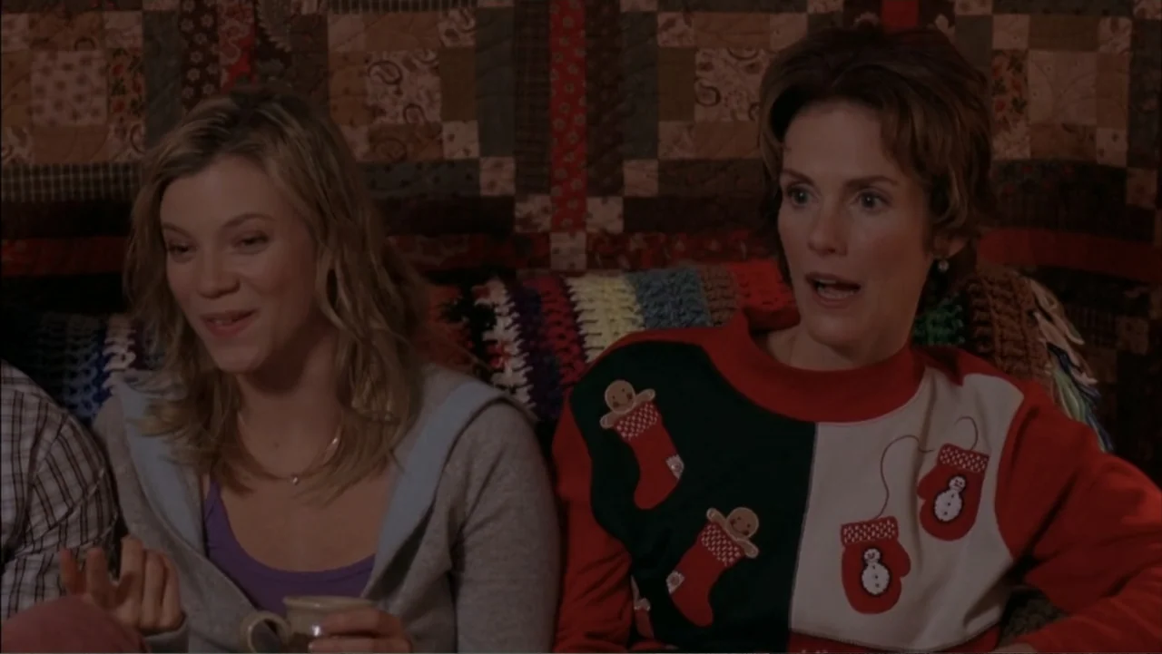 Just Friends (2005) movie still: medium — Two women sit on a sofa in front of a patterned fabric backdrop. The older woman looks toward her…