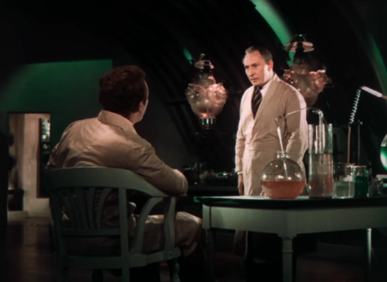 Doctor X (1932) movie still: medium — An arched-ceiling laboratory contains various glass beakers and complex glowing electrical apparatuses. One…