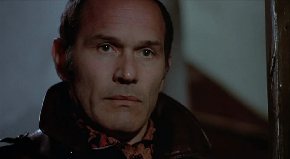 The French Connection (1971) movie still: closeup — A dimly lit indoor space with textured surfaces visible in the out-of-focus background. A…