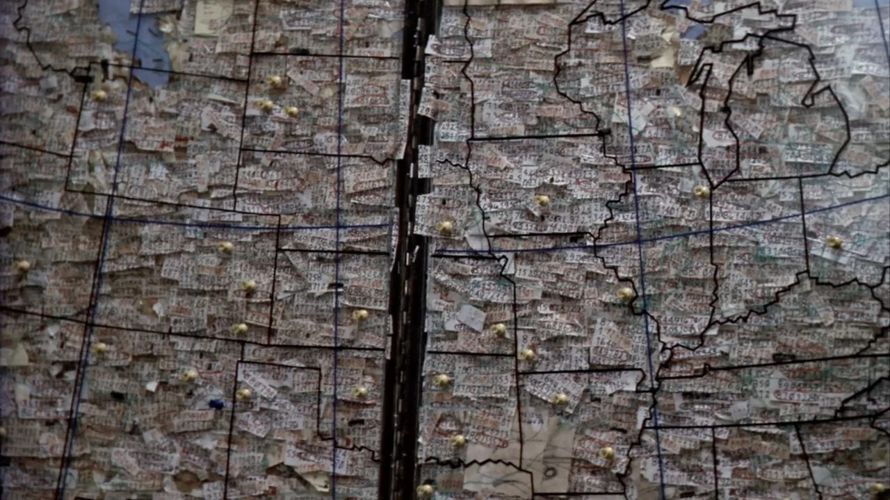 Suspect Zero (2004) movie still: closeup — A large map of the United States is affixed to a vertical wall surface. The map is entirely obscured by…