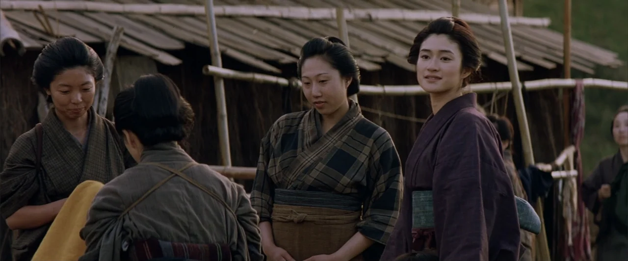 The Last Samurai (2003) movie still: medium — Three Japanese women wearing traditional kimonos stand outdoors near a bamboo framed wall. The women…