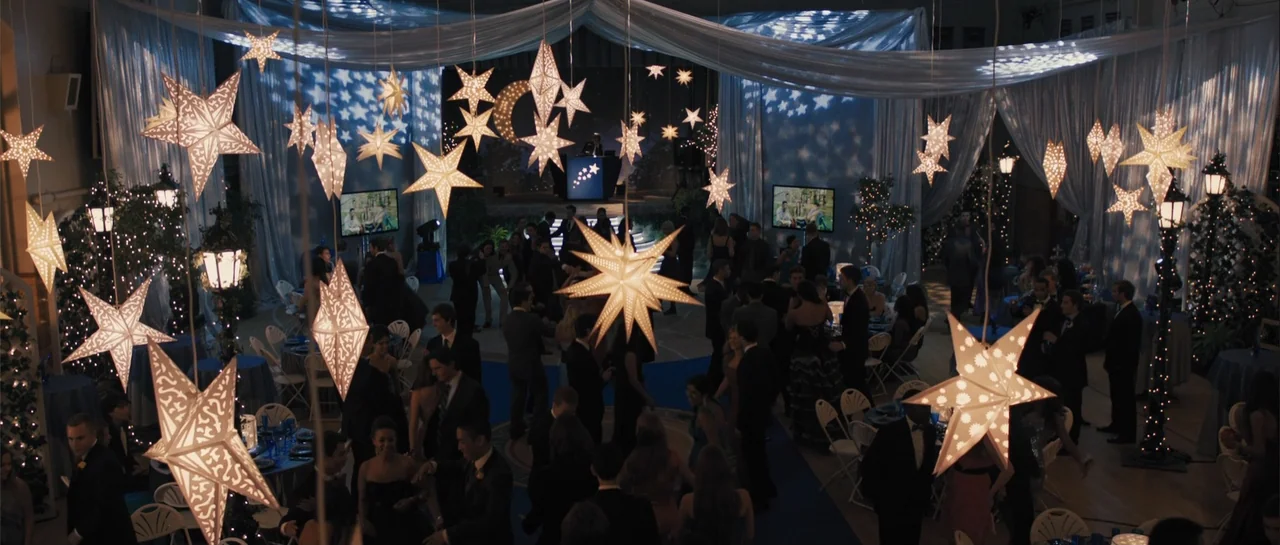 Carrie (2013) movie still: wide — A high school gymnasium decorated with draped fabric and hanging star-shaped paper lanterns. A crowd of teenagers…