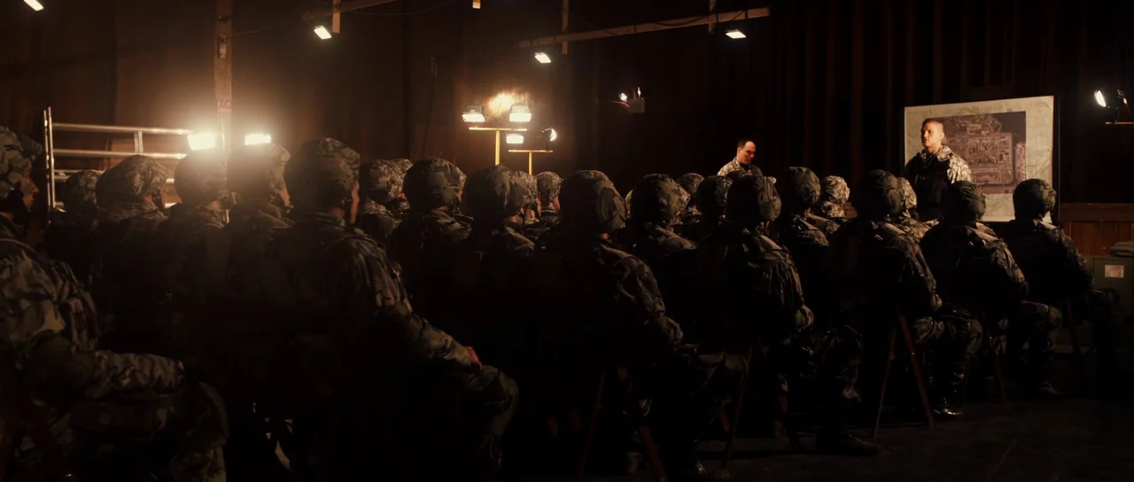 Universal Soldier: Regeneration (2009) movie still: wide — A dark, industrial space occupied by a large group of soldiers in camouflage uniforms.…
