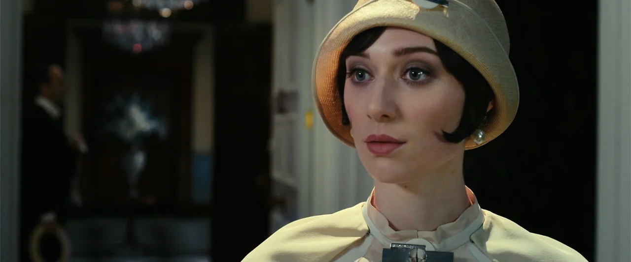 The Great Gatsby (2013) movie still: closeup — A well-lit interior of a 1920s residence featuring high-ceiling architecture and blurred crystal…