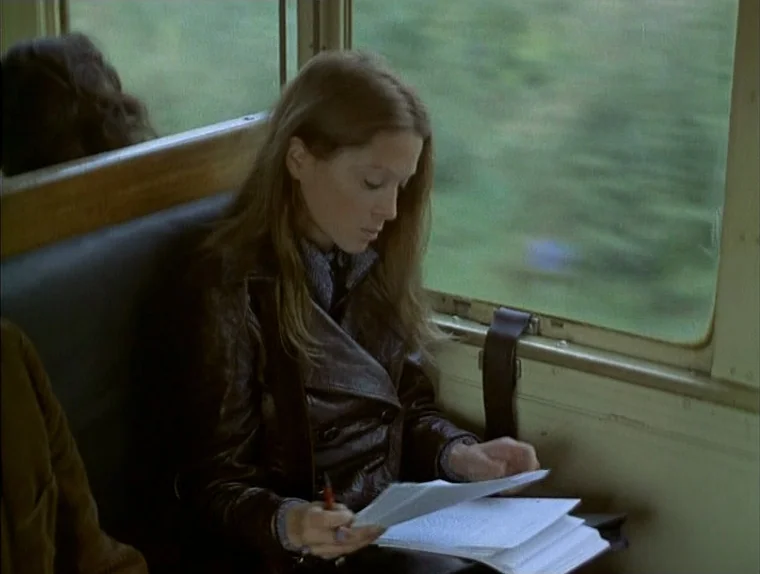 Love In The Afternoon (Chloe In The Afternoon) (L’amour l’après-midi) (1972) movie still: medium — A woman sits inside a vintage train car with…