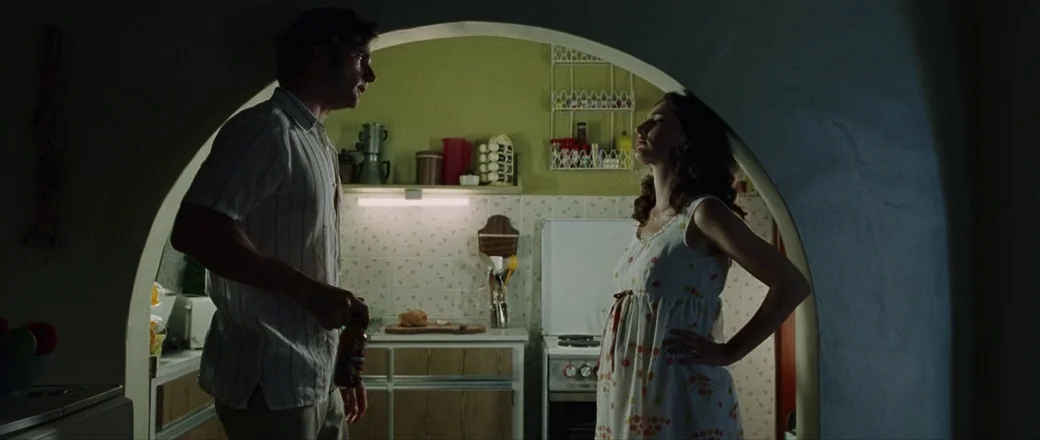 Munich (2005) movie still: medium — A modest kitchen features lime green walls and tiled counters within an arched frame. A man in a striped shirt…