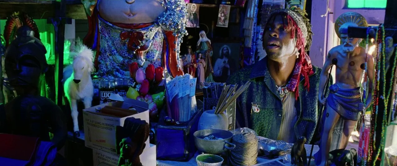 Bad Boys II (2003) movie still: medium — A dark retail shop filled with religious statues, candles, and mystical ritual objects. A man with…