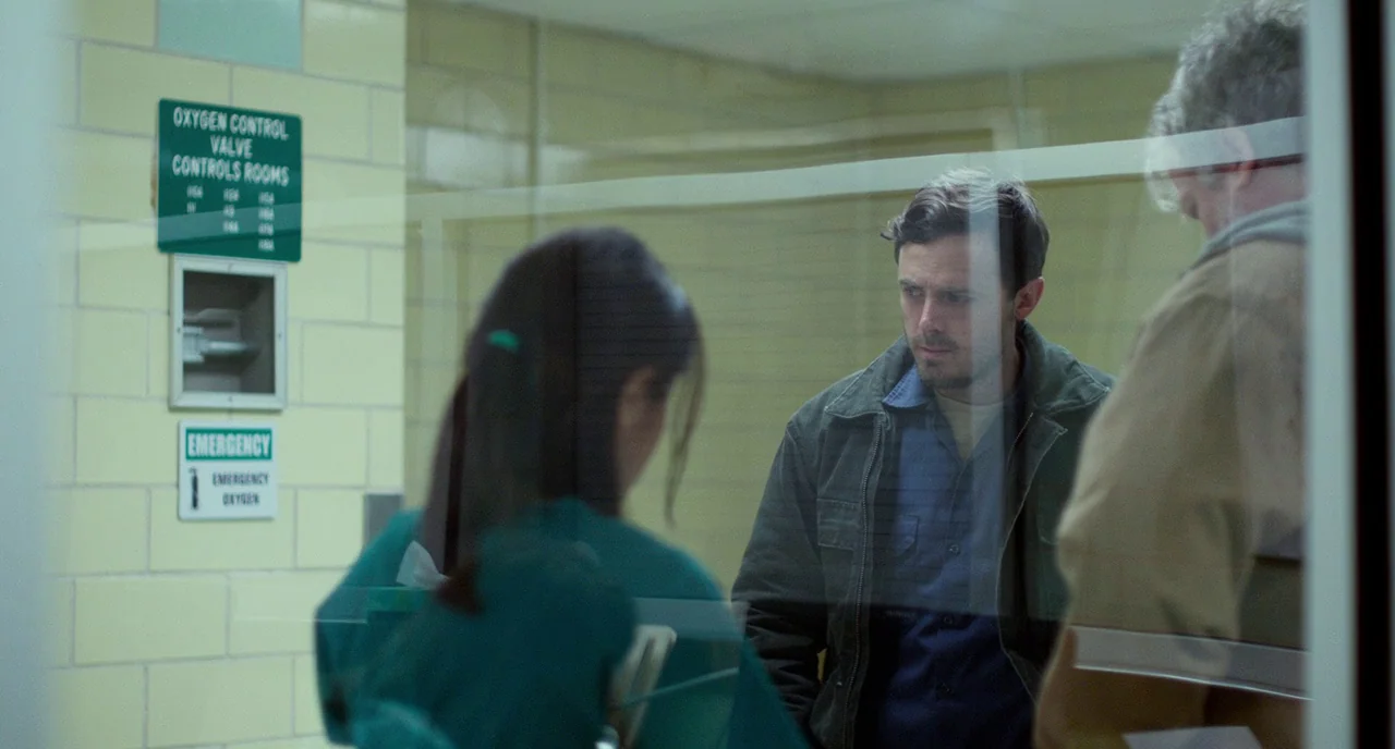 Manchester By The Sea (2016) movie still: medium — A hospital hallway features yellow-tiled walls with an oxygen control valve sign mounted…
