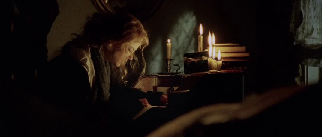 Cold Mountain (2003) movie still: medium — A dimly lit room features a woman working at an antique roll-top desk. She writes on a piece of paper…
