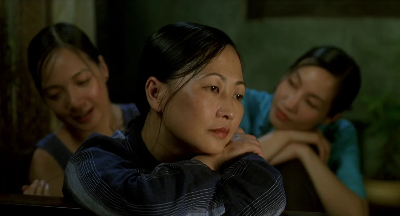 The Vertical Ray of the Sun (2000) movie still: medium — A dark indoor space with three Asian women positioned close together. They rest their heads…