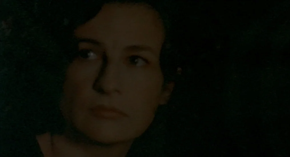 Vendredi Soir (2002) movie still: closeup — A dimly lit, shadowed space obscures all environmental details behind the central subject. A woman with…