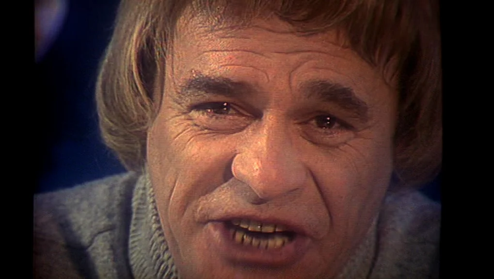 The War of the Worlds: Next Century (1981) movie still: closeup — A close portrait of an older man in a knit sweater. The subject stares ahead while…