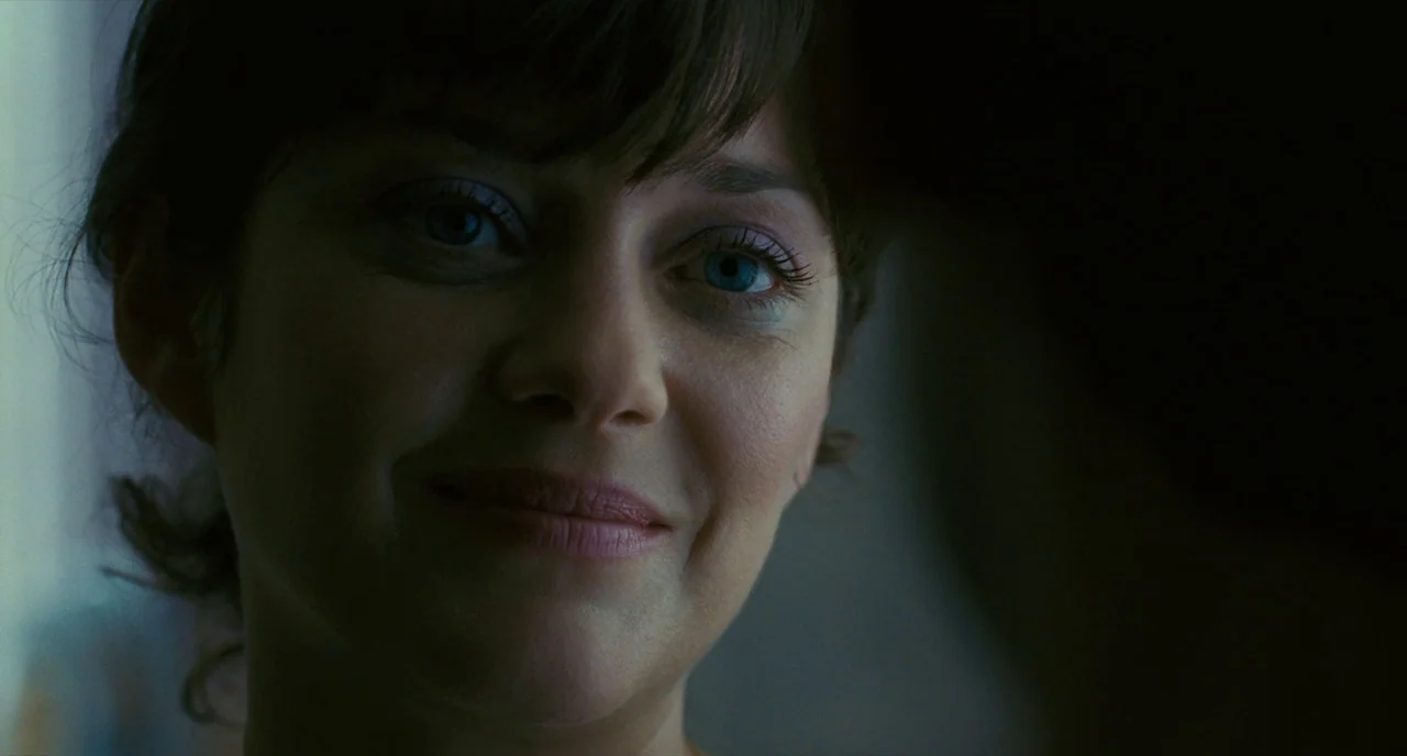 It’s Only The End Of The World (2016) movie still: closeup — A dimly lit indoor space with shadows obscuring the background. A woman looks toward…