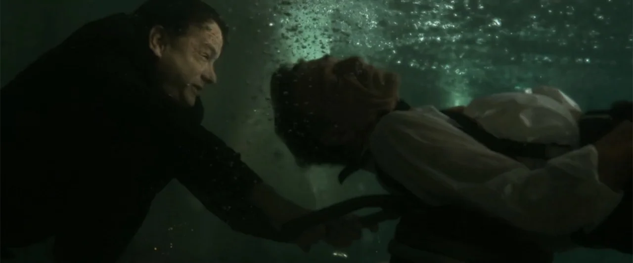 Angels & Demons (2009) movie still: medium — Two men struggle underwater in a dark, murky environment filled with air bubbles. One man reaches out…
