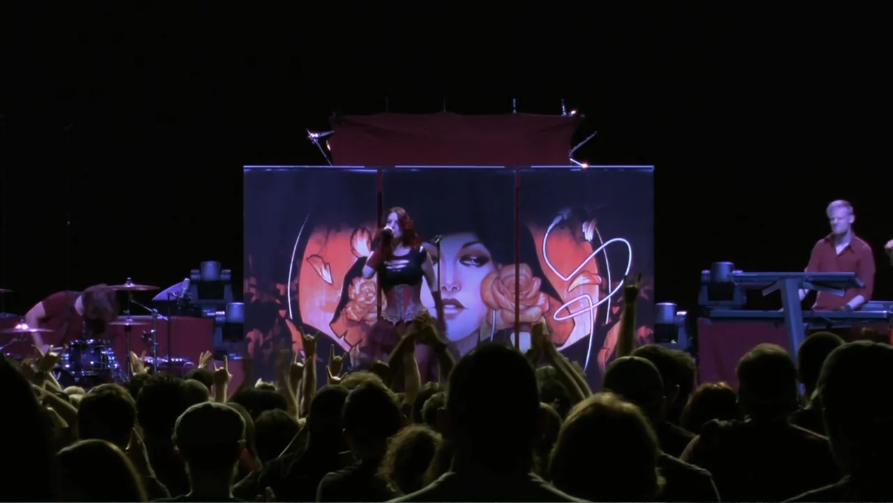 Soaring Highs and Brutal Lows: The Voices of Women in Metal (2015) movie still: medium — A dimly lit concert stage features a female singer framed…