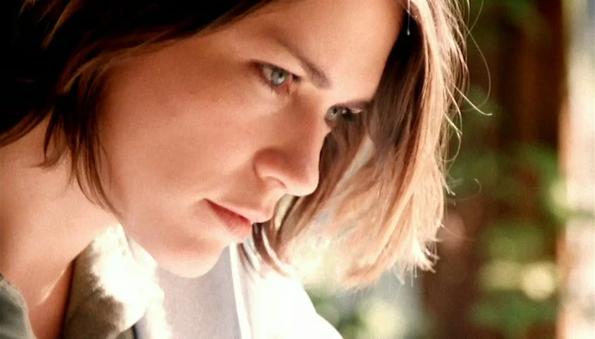 Maelström (2000) movie still: closeup — An interior space with bright, soft light cast against a light-colored wall. A woman with shoulder-length…
