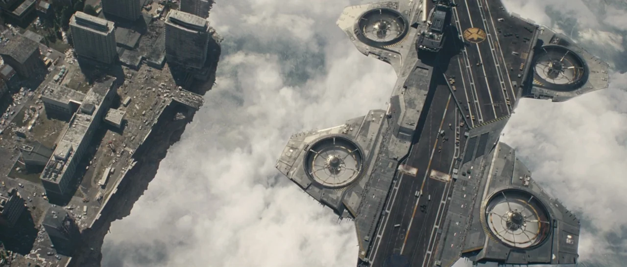 Avengers: Age of Ultron (2015) movie still: establishing — A massive armored carrier floats high above a cloud layer adjacent to a city. The large…