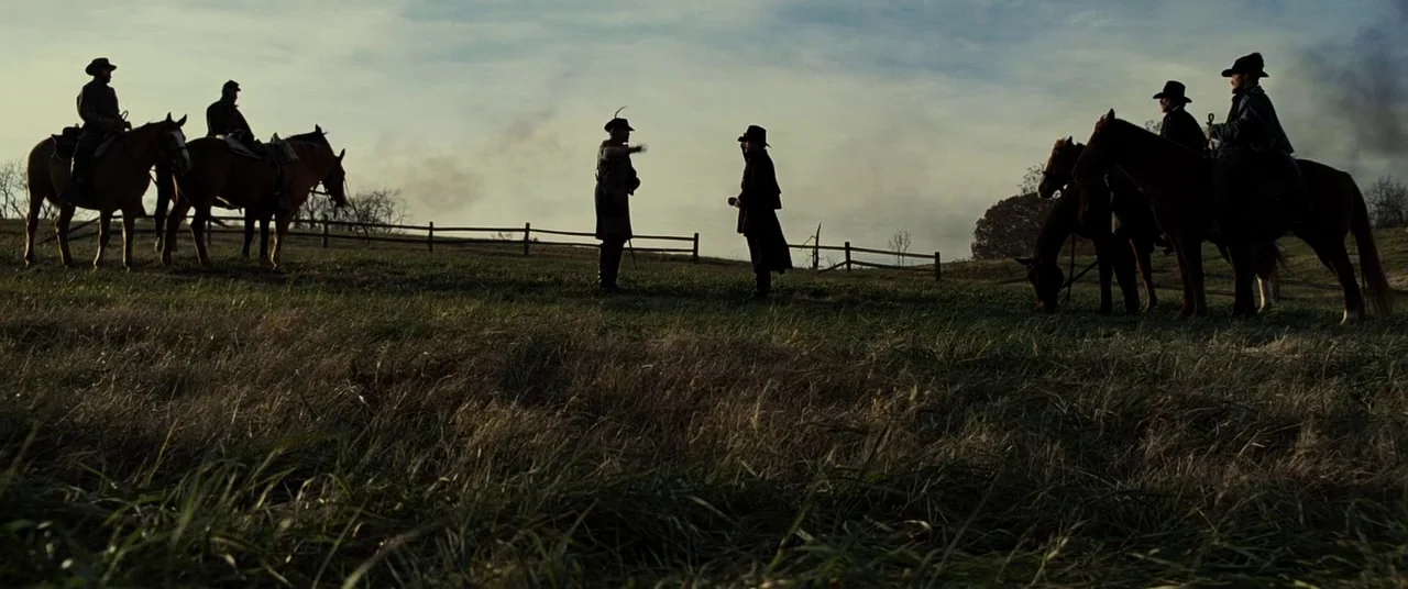 Lincoln (2012) movie still: wide — An open grassy field during the day with a wooden fence stretching across. Several men in period military attire…