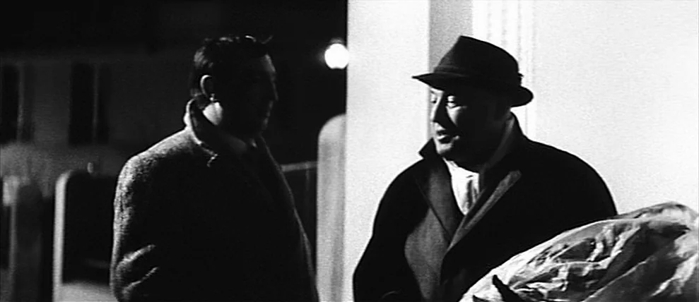 Shoot The Piano Player (Tirez Sur Le Pianiste) (1960) movie still: medium — Two men stand together at night against a stark white wall in the dark.…