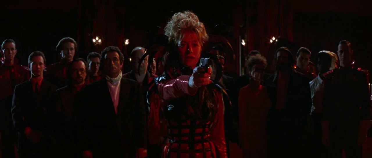 The Cook, The Thief, His Wife & Her Lover (1989) movie still: medium — A dark ballroom interior filled with a crowd of people in formal attire. A…