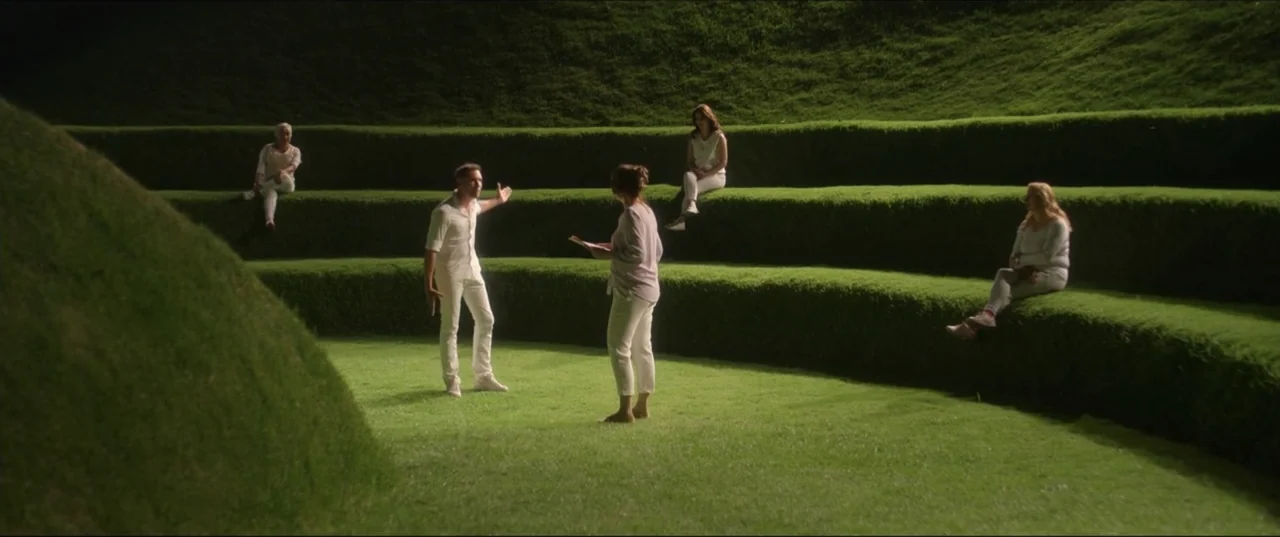 Can't Quit Mom (2022) movie still: wide — A natural grass amphitheater features tiered levels forming seating in a curved, open-air arrangement. A…