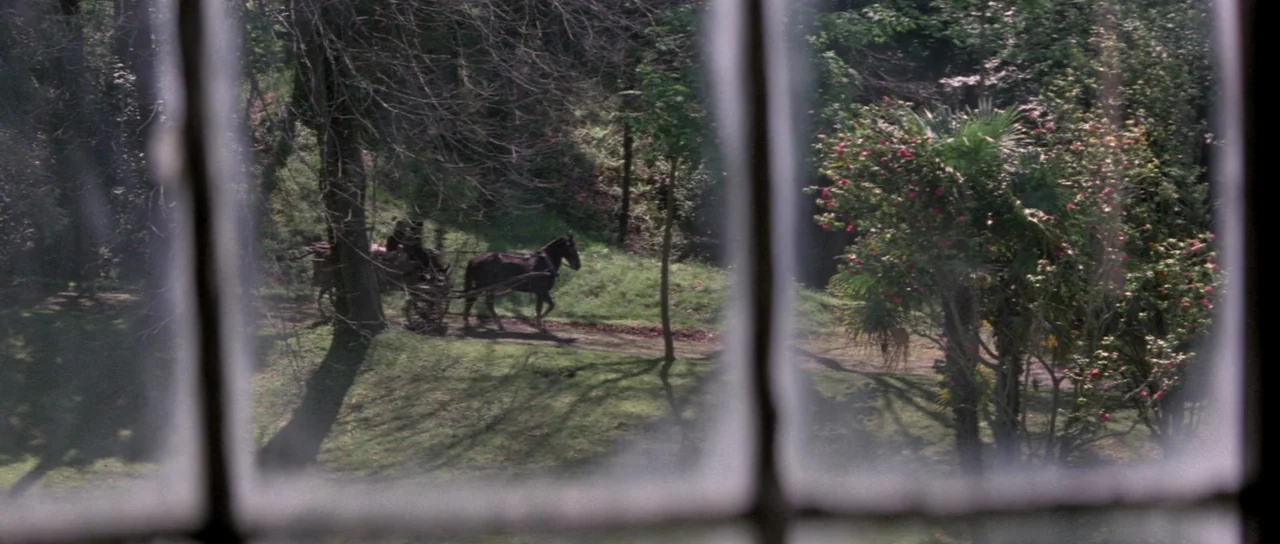 The House That Screamed (1969) movie still: wide — A view through a window showing a horse-drawn cart on a dirt path. Green grassy slopes and…