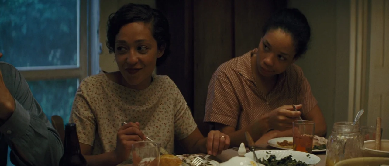Loving (2016) movie still: medium — A 1950s dining room with simple wooden furniture and home-cooked meals served on plates. Two women sit across…
