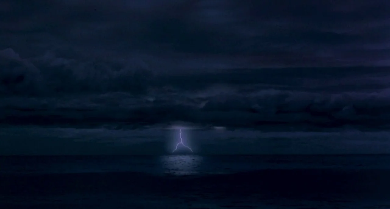 The Craft (1996) movie still: establishing — A dark, storm-filled night stretches over an expansive, turbulent body of deep ocean water. A bright…