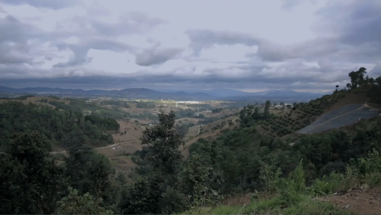 Torn Apart: Separated at the Border (2019) movie still: establishing — A vast mountain valley stretches toward the horizon under a dense blanket of…