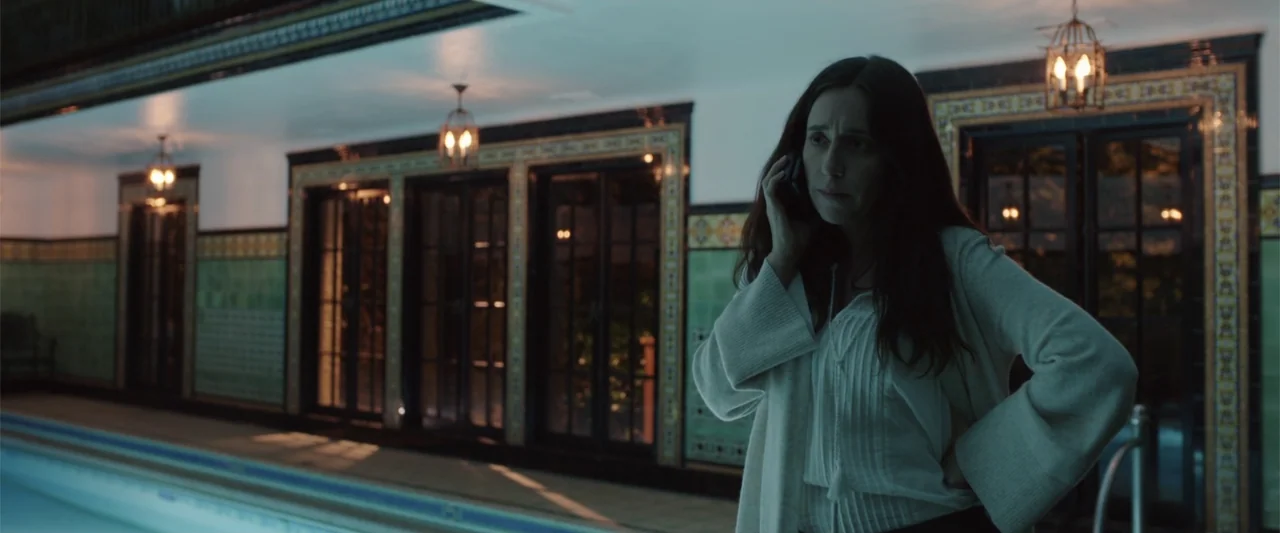 Overboard (2018) movie still: medium — An indoor pool area features tiled walls, dark windows, and hanging ornamental lantern fixtures. A woman…