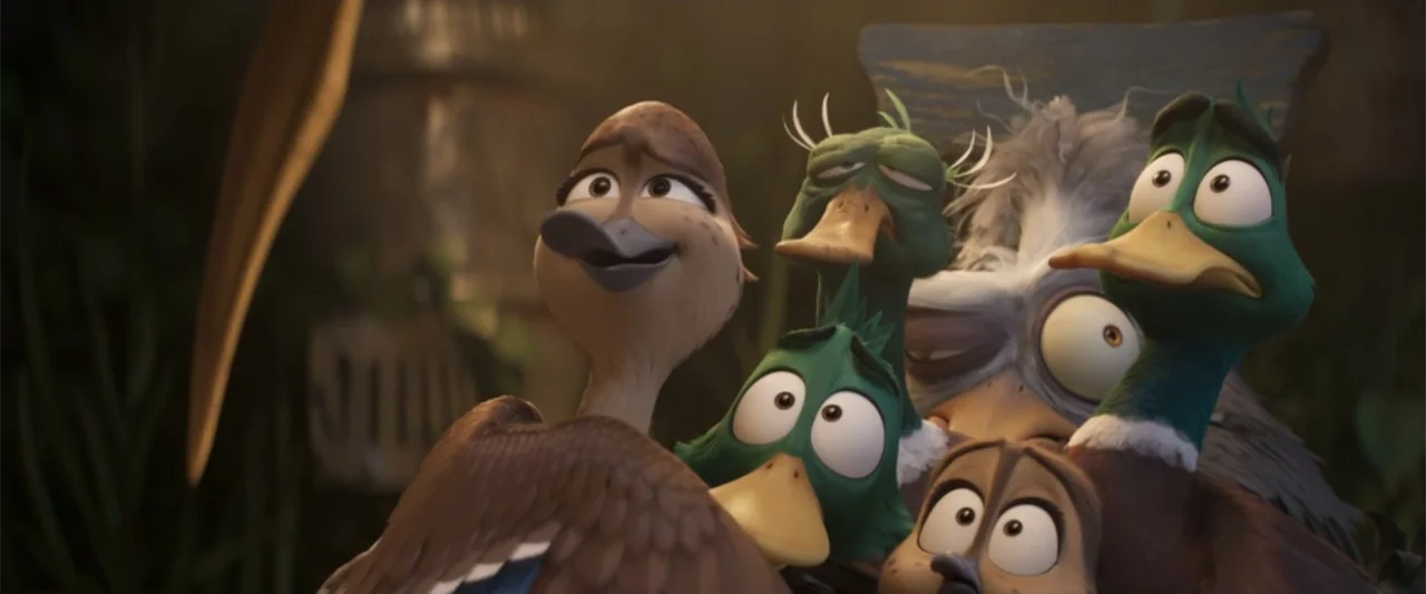 Migration (2023) movie still: medium — A dimly lit interior space contains a cluster of animated ducks. The ducks huddle together and look to the…