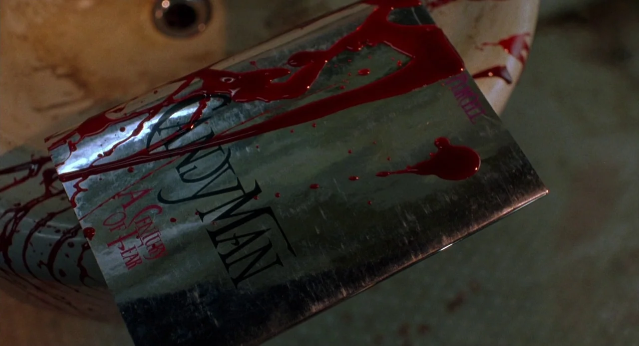 Candyman: Farewell to the Flesh (1995) movie still: closeup — A silver metal plate inscribed with film title text rests in a basin. Viscous red…