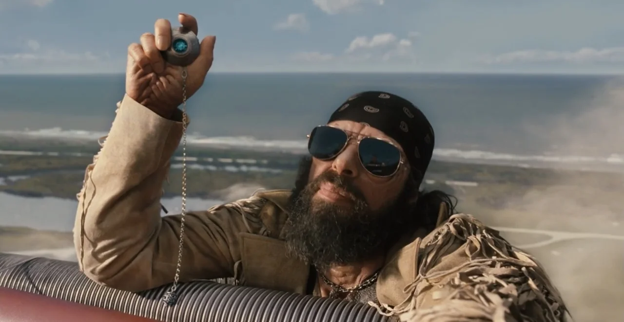 Men in Black 3 (2012) movie still: medium — An open coastal landscape overlooks a calm sea under a partly cloudy sky. A man with a dark beard…