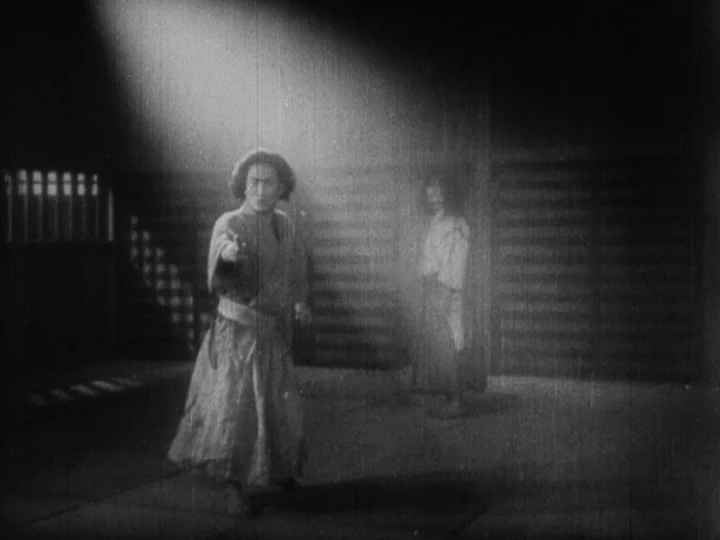 Sanshiro Sugata Part II (1945) movie still: fullbody — An interior of a dark building with sliding doors and tatami flooring. A man stands in a…