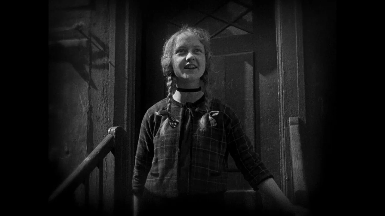 Master of the House (1925) movie still: medium — A dark, narrow outdoor staircase leads to a wooden door at night. A young woman stands on the…