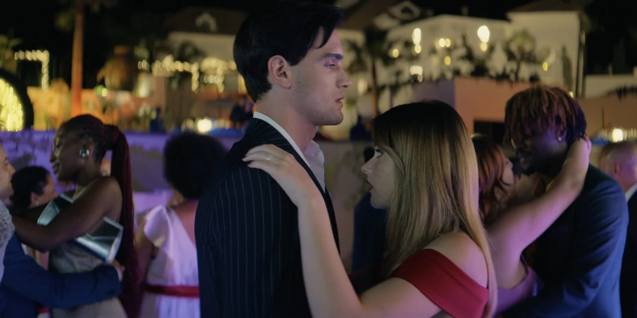 Our Fault (2025) movie still: medium — An outdoor evening party with blurred lights of a building in the background. A young man and woman face each…