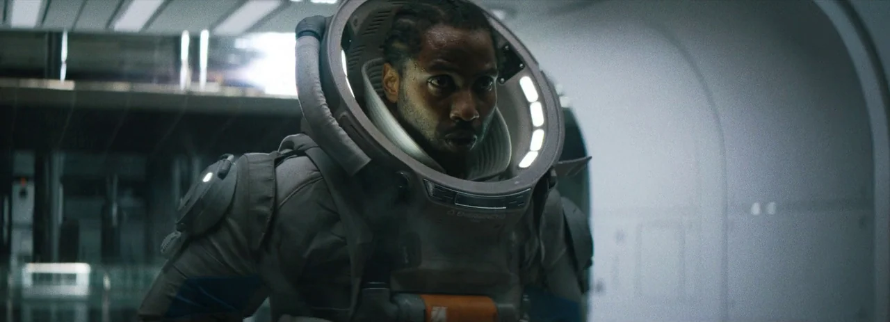 The Creator (2023) movie still: medium — A sterile, white-walled corridor features smooth curved surfaces typical of advanced spacecraft interiors.…