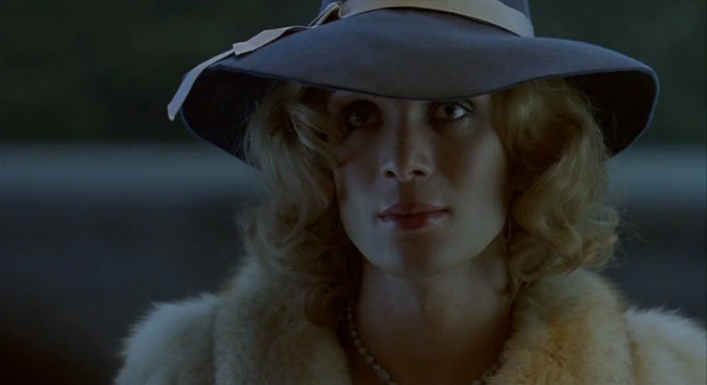 Breakfast On Pluto (2005) movie still: closeup — A dimly lit interior space serves as the setting for the close-up shot. A person wearing a vintage…