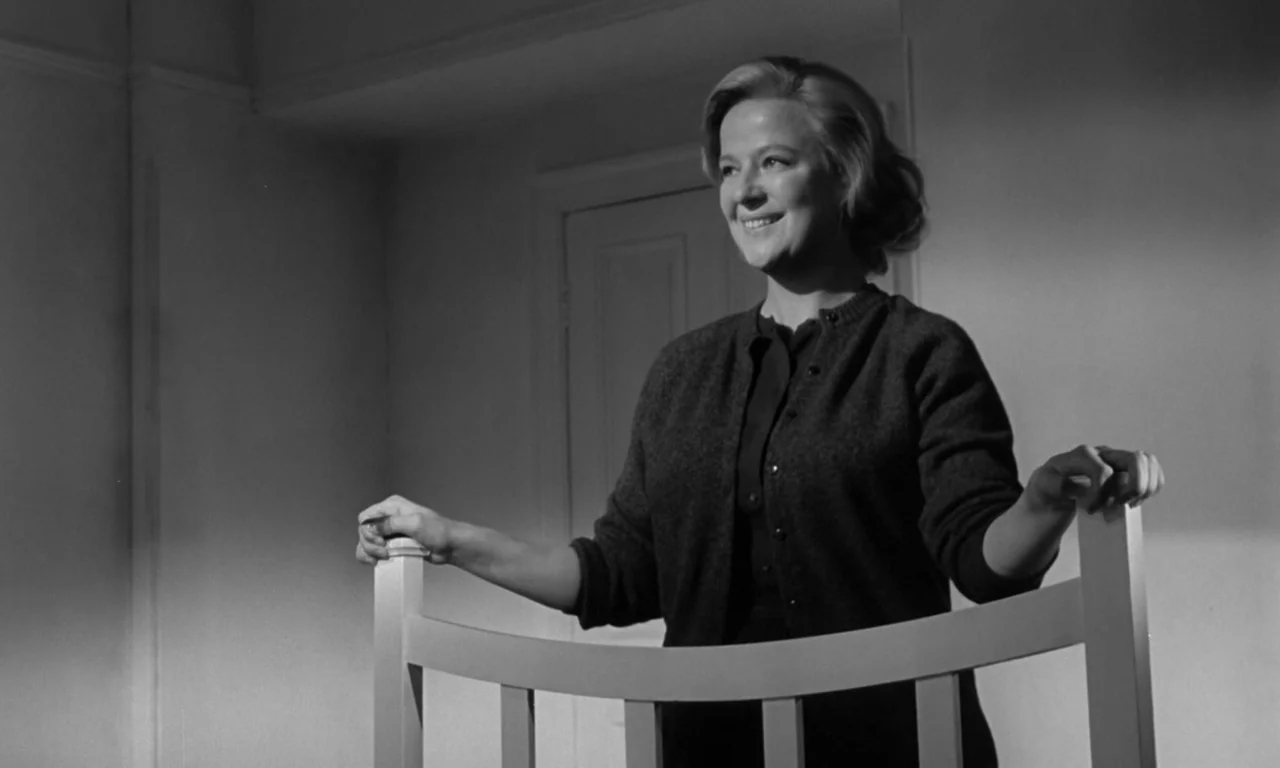 Seance on a Wet Afternoon (1964) movie still: medium — A sparsely furnished room with light-colored walls and a closed door in the background. A…