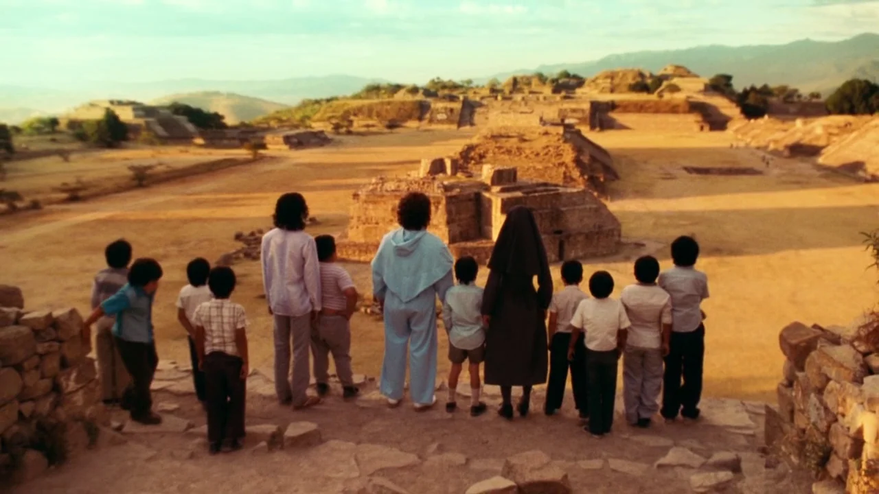 Nacho Libre (2006) movie still: wide — A vast, sun-drenched archaeological site features stone pyramids and a central earthen plaza. A line of…