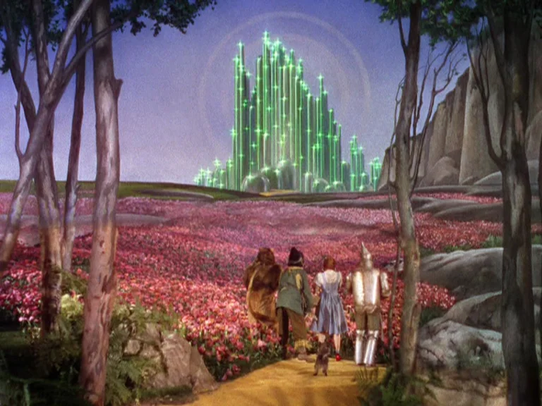 The Wizard Of Oz (1939) movie still: establishing — A vast field of pink flowers leads toward a sparkling emerald city on the horizon. Four…
