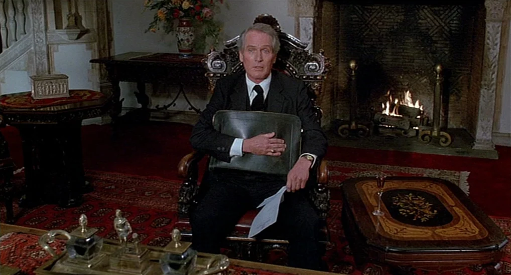 The Verdict (1982) movie still: medium — An opulent room features a stone fireplace, red rugs, and ornate antique furniture. A mature man in a suit…