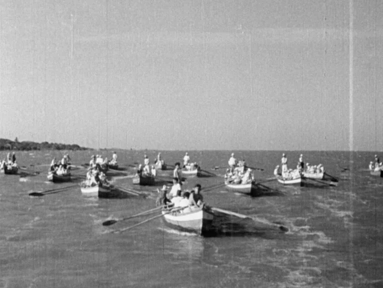 Redes (1936) movie still: wide — A fleet of small rowboats moves across a calm, large body of water. Numerous people occupy the boats, actively…