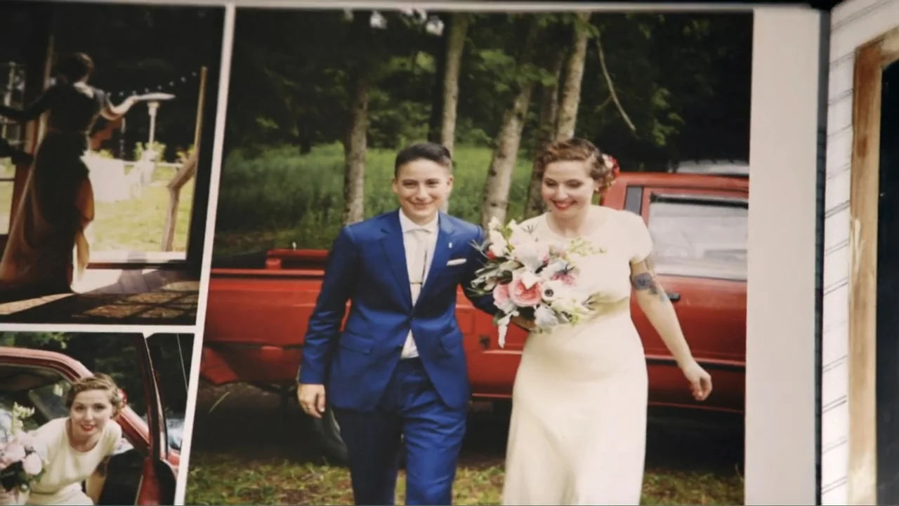 Suited (2016) movie still: medium — A wedding photograph shows a couple standing outdoors with a red pickup truck behind them. The two individuals…