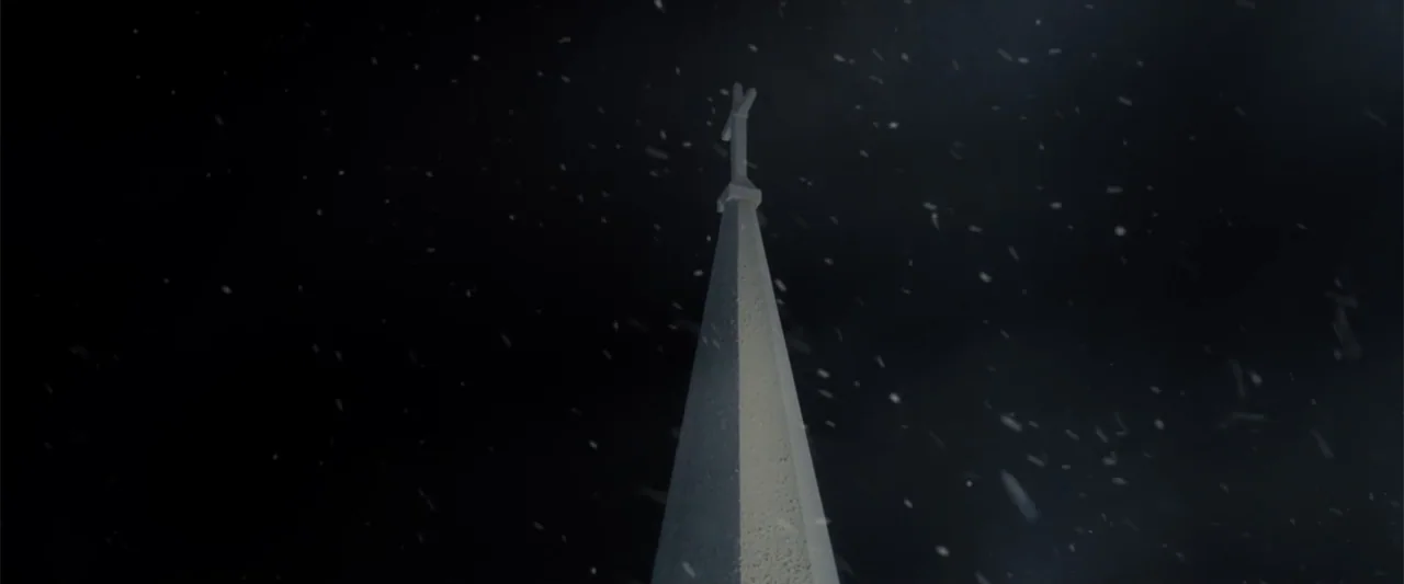 I Heard the Bells (2022) movie still: establishing — A tall stone church steeple reaches into a dark, snowy night sky. The structure is illuminated…