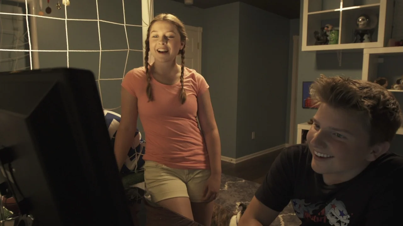 Sk8 Dawg (2018) movie still: medium — A contemporary bedroom features dark blue walls and white shelving filled with decorative items. A teenage…
