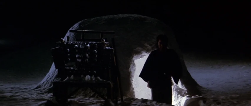 Lone Wolf and Cub: White Heaven in Hell (1974) movie still: wide — A lone man emerges from an illuminated opening in a large dome-shaped snow…